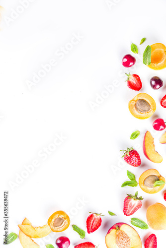 Summer background with fresh fruits and berries on white background. Set of various seasonal fruit and berry  - strawberry, apricots, peach slices, cherry, mint. Flat lay. Summer fruits concept.