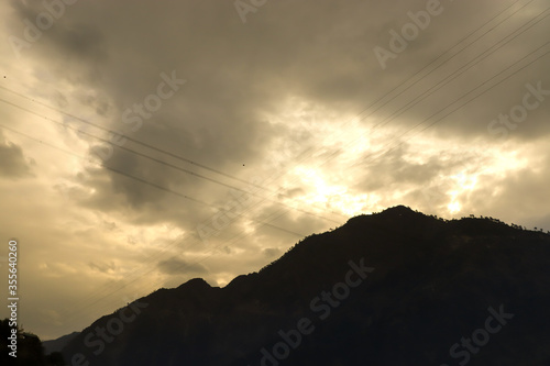 yellow clouds on the background with a mountain in front. silhouette. focus on infinity