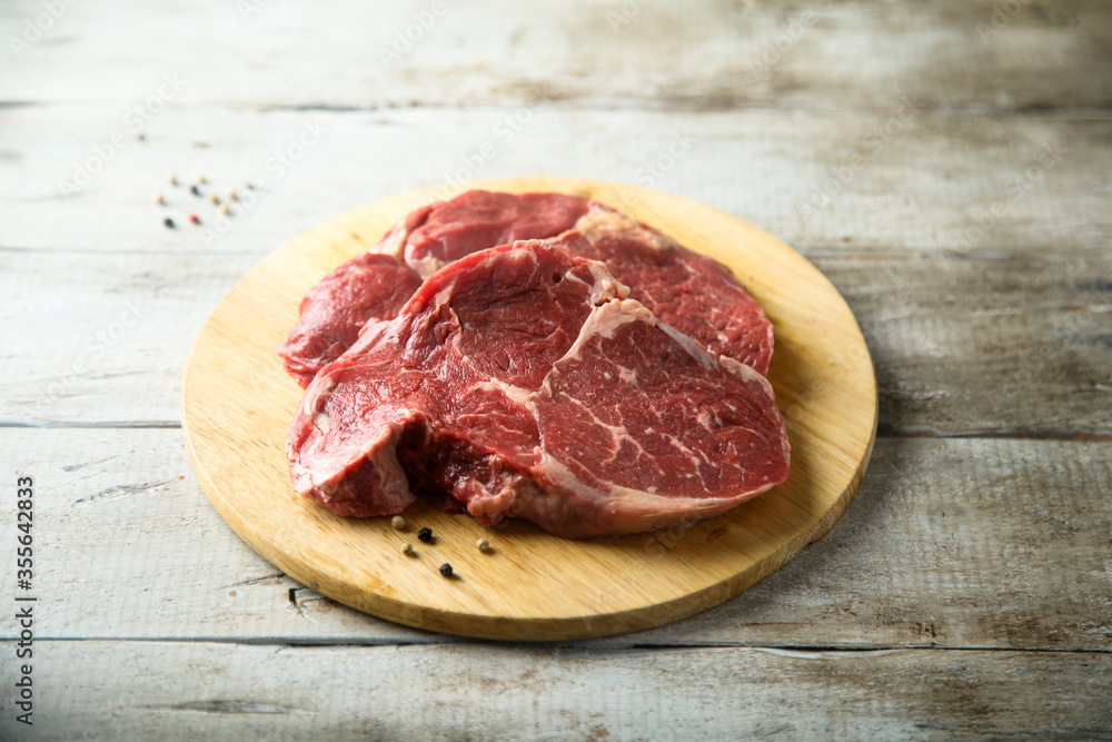 Raw beef steak on wooden desk Raw beef steak on wooden desk