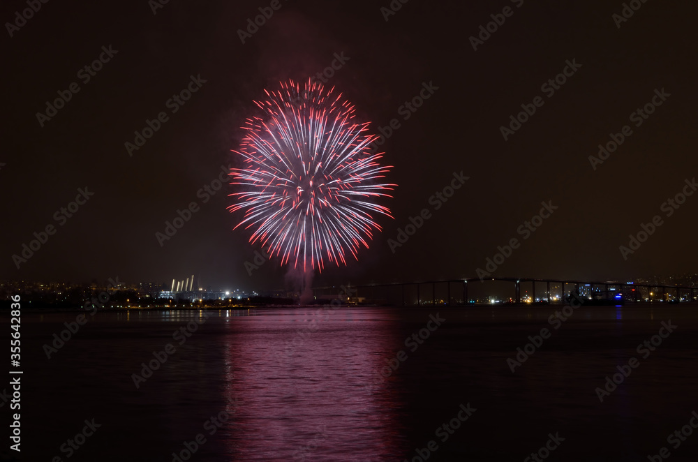 Beautiful firework on night sky in tromsoe city with bridge, cathedral and colorful reflection on the cold fjord water surface on new years eve Beautiful firework on night sky in tromsoe city with bridge, cathedral and colorful reflection on the cold fjord water surface on new years eve