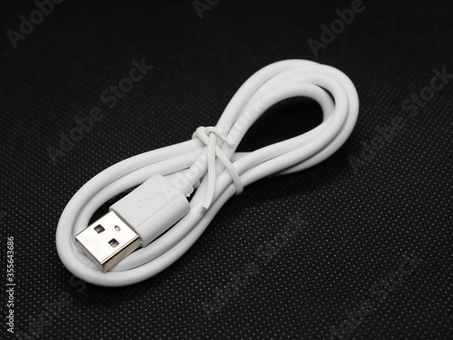 A white usb cable on a black background