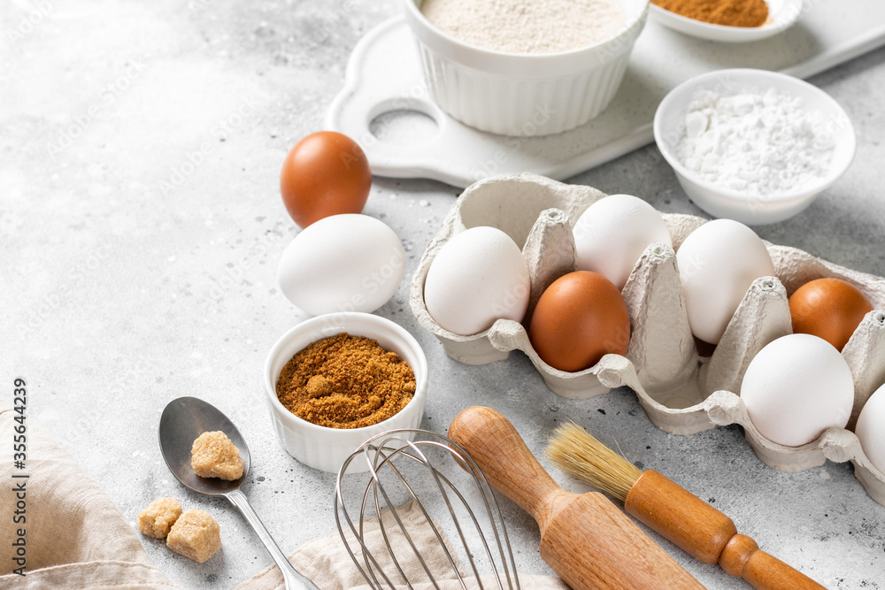 Ingredients for baking on a culinary background. Eggs, flour, cinnamon, sugar, soda on the kitchen table. Concept of preparation for baking. Top view with space for text Ingredients for baking on a culinary background. Eggs, flour, cinnamon, sugar, soda on the kitchen table. Concept of preparation for baking. Top view with space for text