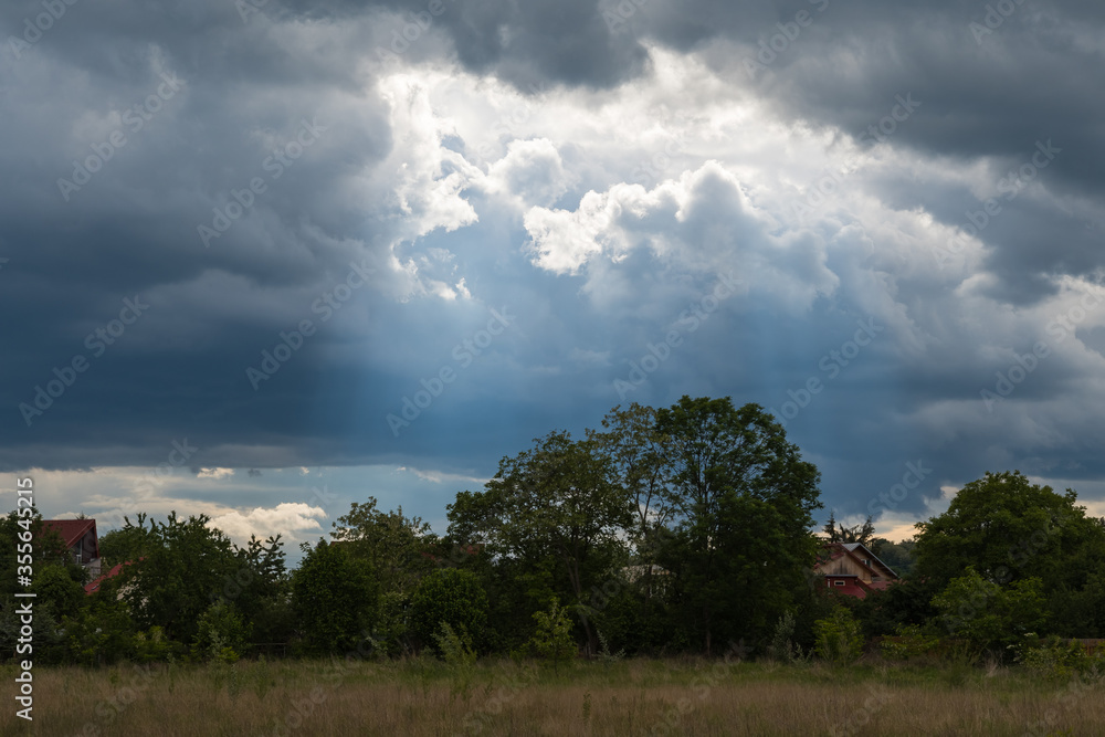 Obraz premium Magic Blueish Light Passing through the Dark Stormy Clouds