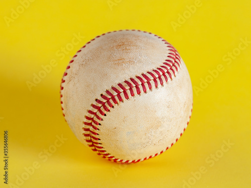 worn baseball isolated on yellow background, team sport