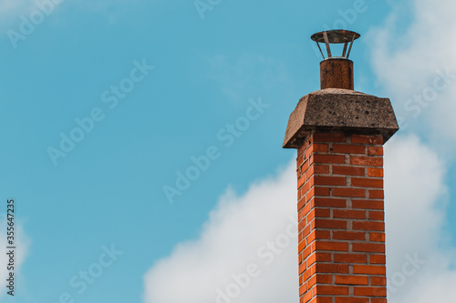 Fotografie Red brick chimney and cloudy sky