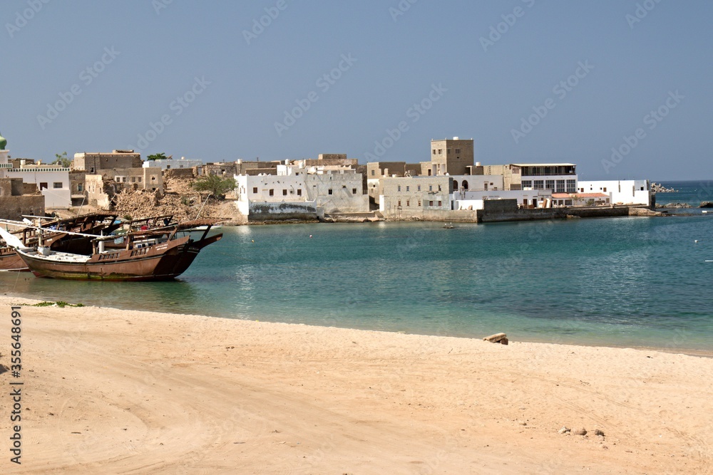 View of Mirbat town, moored boats and Arabian sea. Oman. Asia.
