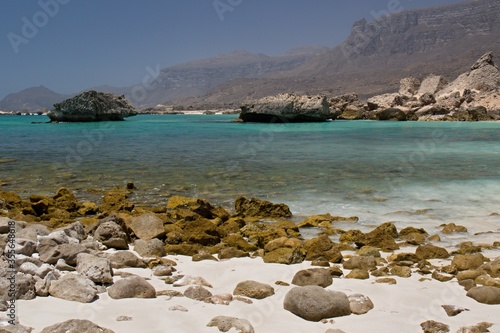 The beautiful beaches of Fazayah, without tourists above the scenic rocky mountain range, are located 60 miles south of Salalah. Arabian sea. Oman, Asia photo