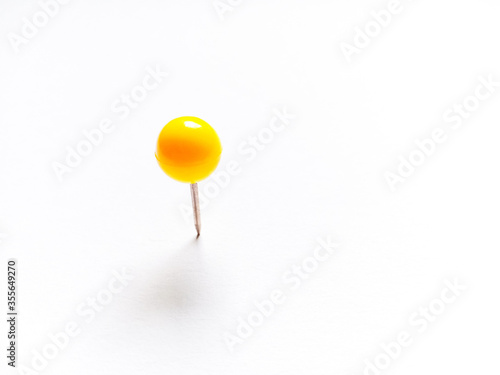 Yellow push pins on white background