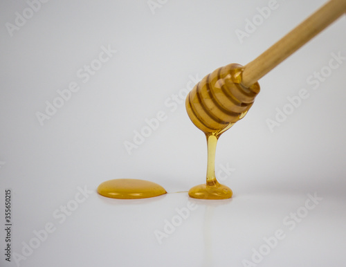 Honey dripping isolated on a white background. Natural remedy and prevention for diseases