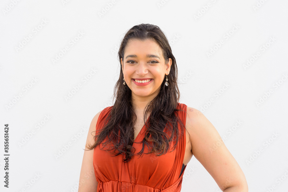 Face of happy young beautiful Indian woman smiling against white background Face of happy young beautiful Indian woman smiling against white background