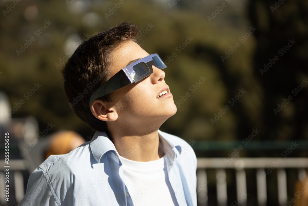 impressed teenager looking at a sun eclipse with eclipse glasses impressed teenager looking at a sun eclipse with eclipse glasses