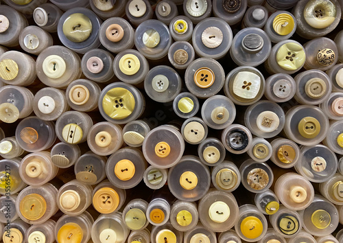 Close up of isolated stacked round boxes in an row with countless trouser buttons