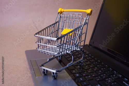 E-Commerce. Online shopping, shopping cart on laptop keyboard.