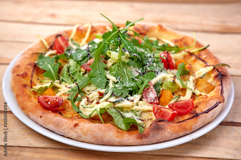 pizza with fresh vegetables on the wooden background