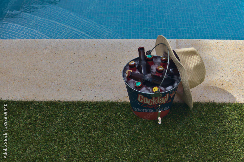 Quintos de cerveza en un cubo con hielo puesto en la coronación de una
