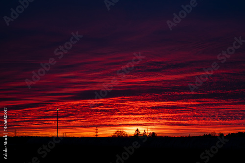 Blurred background. Natural Sunset Over Field Or Meadow. Bright Dramatic Sky And Dark Ground.  