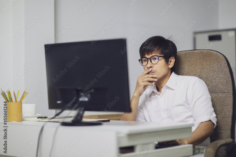 Young asian man working from home with computer. Businessman working at his home in the living room home. Work from home during coronavirus disease concept.. Young asian man working from home with computer. Businessman working at his home in the living room home. Work from home during coronavirus disease concept..