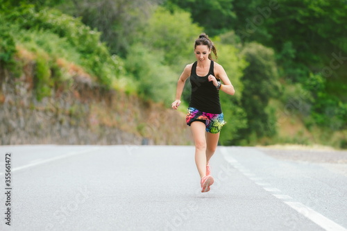 Woman running alone on the asphalt