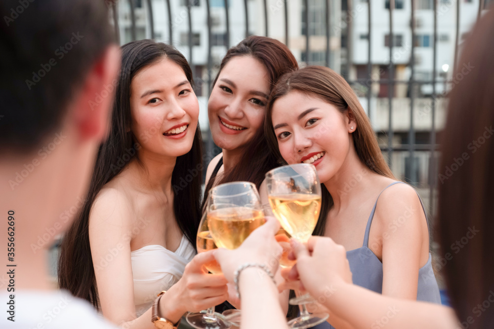 Group of young Asian friends are toasting or cheering Group of young Asian friends are toasting or cheering
