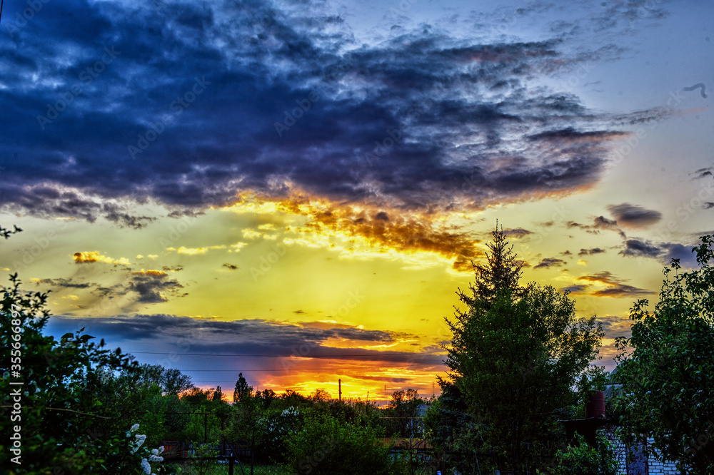 Naklejka premium clouds and sunset over the village in spring1