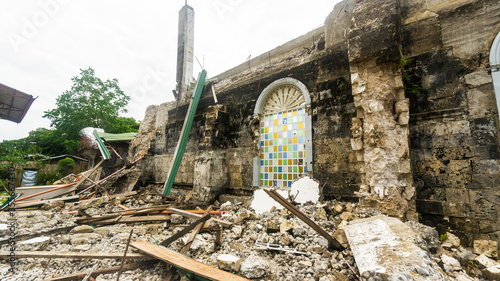 фотографія A heavily damaged church with intact stained glass windows