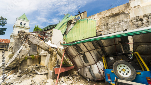Obraz na plátne A heavily damaged church, and a jeep crushed by debris