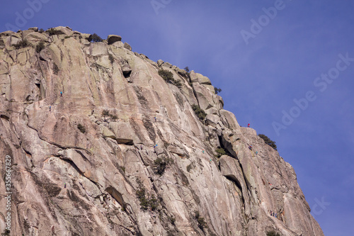 Pico de la Miel, Madrid, Spain. General view of Rock climbers climbing granite rock formation called The Honey Peak.