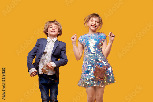 Brother and sister have fun, dance and laugh. Children in fancy dress.