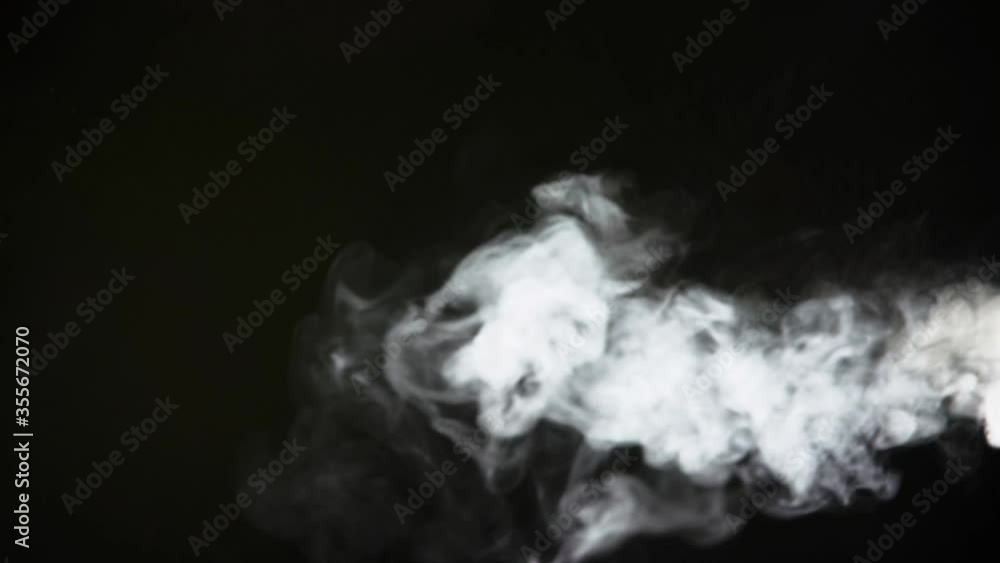 Spooky magic halloween. Atmospheric smoke VFX element. Haze background. Abstract smoke cloud. Smoke in slow motion on black background. White smoke slowly floating through space against black bg Spooky magic halloween. Atmospheric smoke VFX element. Haze background. Abstract smoke cloud. Smoke in slow motion on black background. White smoke slowly floating through space against black bg