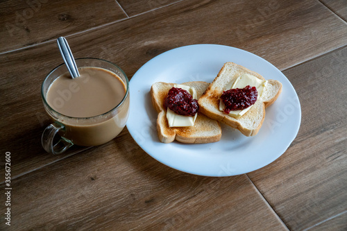 Obraz na płótnie Cup of coffe with milk and two slices of toasted sandwich Bread with Butter and Raspberry Jam a white plate. Healthy breakfast with coffee. Top view. Free space for text. w salonie