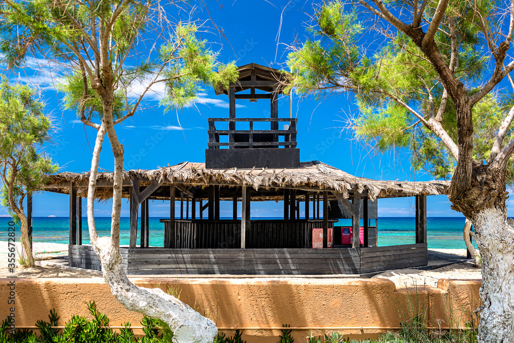Pandemic hits the tourism, deserted beach bar and lifeguard tower during summer season 2020. Blue sky, sea at the background Pandemic hits the tourism, deserted beach bar and lifeguard tower during summer season 2020. Blue sky, sea at the background