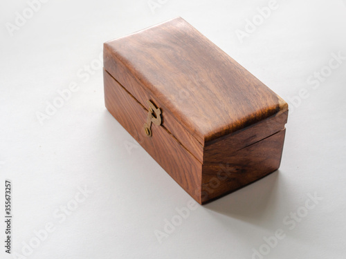 Old wooden box with metallic buckle on a white background