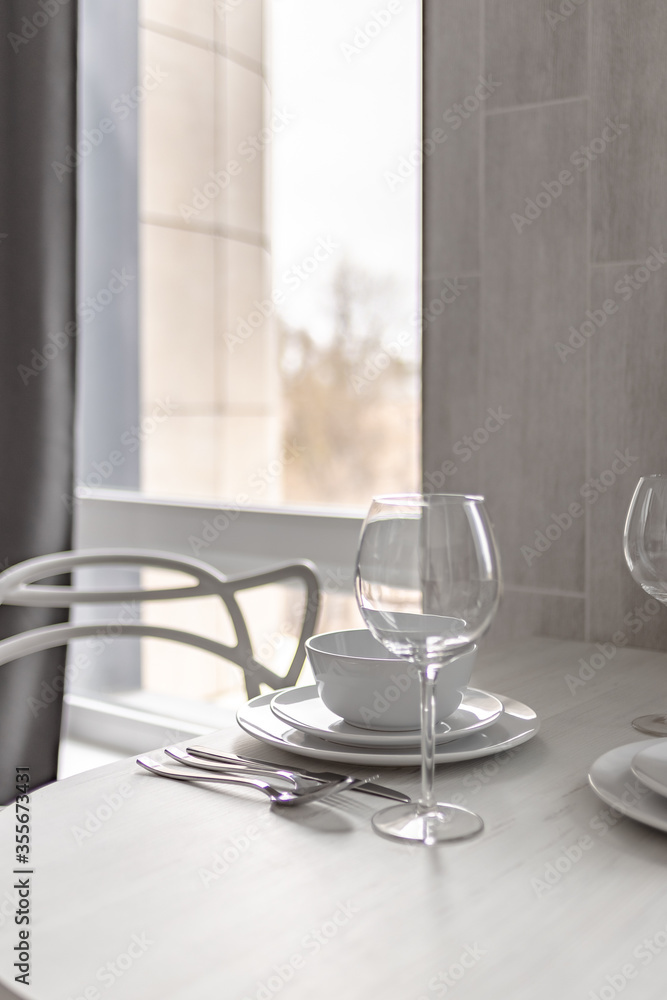 Table setting near the window - plates, wine glass, knife, fork and spoon 0070 Table setting near the window - plates, wine glass, knife, fork and spoon 0070