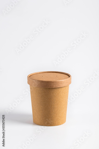 Empty paper soup cup on a white background. Brown food container for ice cream, noodles or other dishes. ecological product that can decompose naturally.