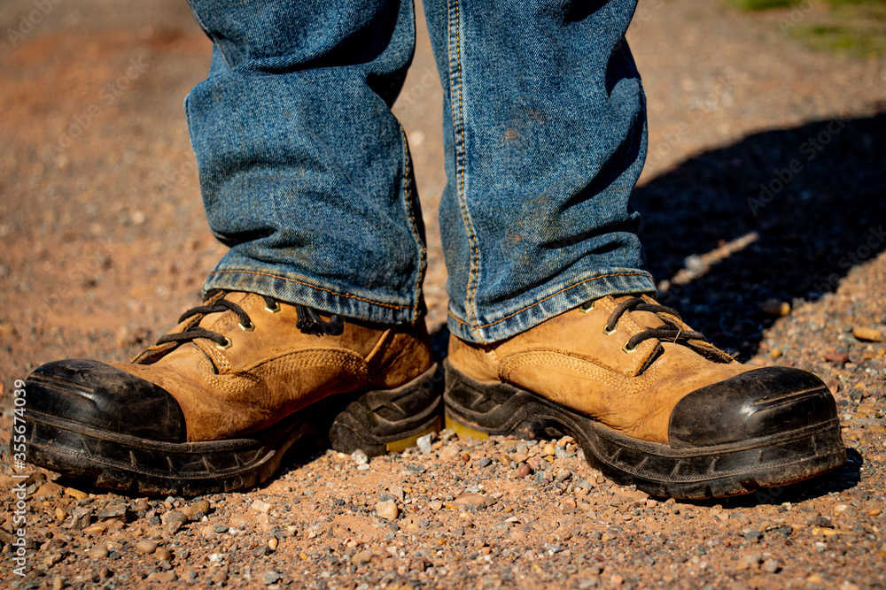 work boots and jeans on gravel road work boots and jeans on gravel road