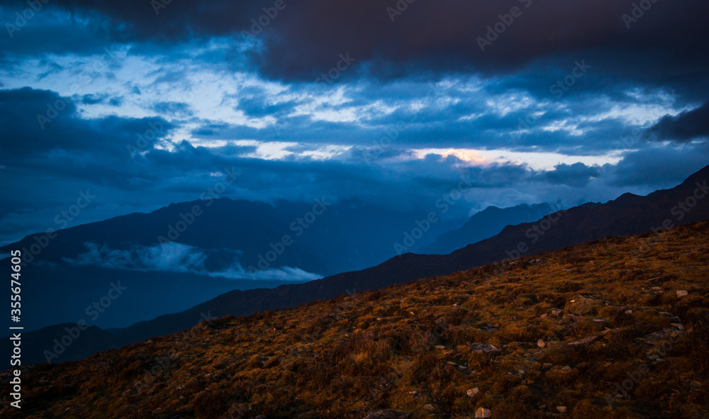 Hills and dark cloud covering during an evening in the mountains. Scene from Lauribinayak on the Gosainkunda lake trail in Langtang region of Nepal. Hills and dark cloud covering during an evening in the mountains. Scene from Lauribinayak on the Gosainkunda lake trail in Langtang region of Nepal.