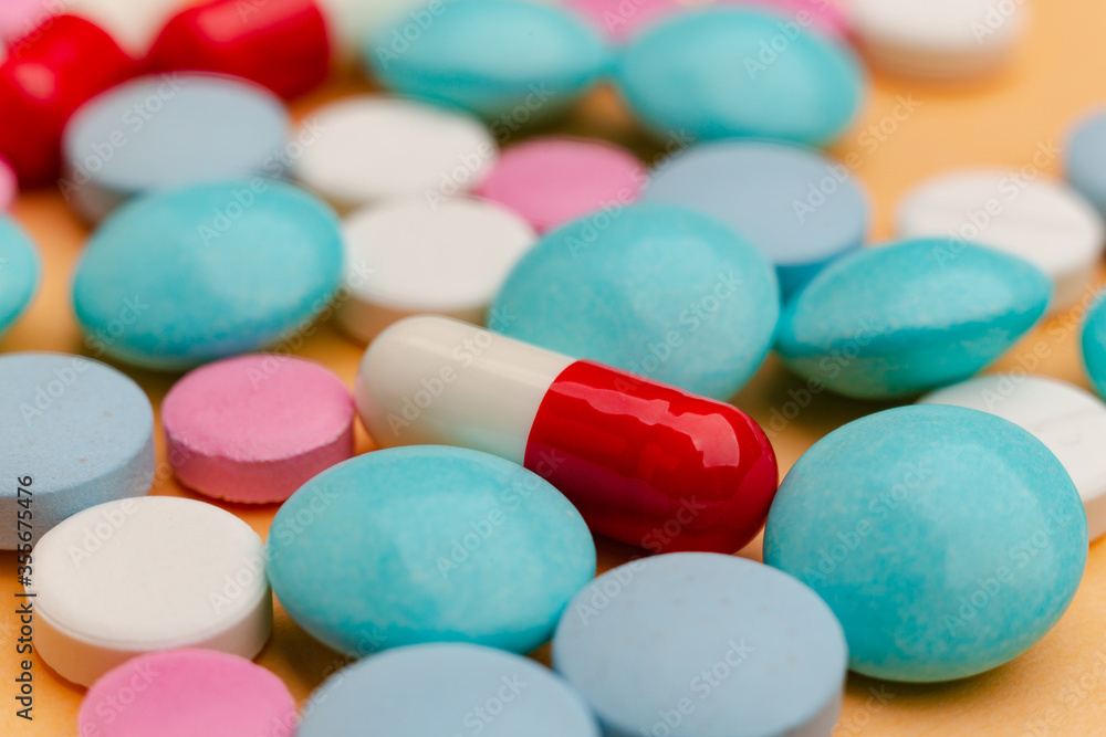 Close up of pills on orange background, concept of painkillers addiction. Lot of tablets, overdose. Close up of pills on orange background, concept of painkillers addiction. Lot of tablets, overdose.
