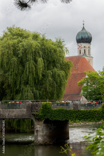 Church of Holy Maria Magdalena and famous old stone bridge over the river Amper in the bavarian town Fuerstenfeldbruck on cloudy overcast day