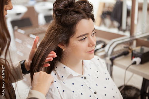 Top view shot of a charming woman having her hair curled by hair stylist
