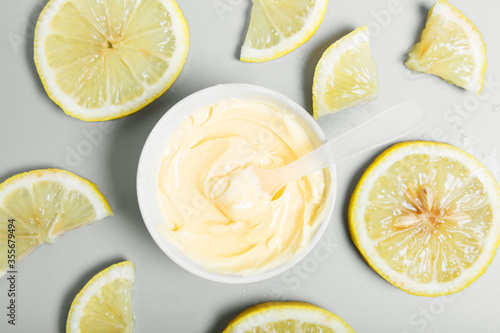  Yellow cream and lemons on a gray background. natural cosmetics and spa concept. Top view, flat lay.