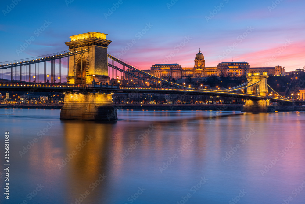 Buda castle with Szechenyi Chain Bridge foreground reflect in Danube river during sunset