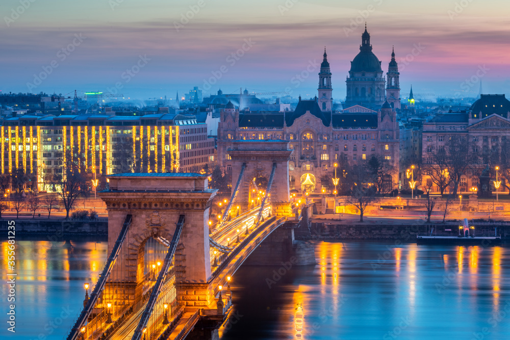 Close up of St. Stephen's Basilica with Szechenyi Chain Bridge reflect in Danube river, Budapest during twilight