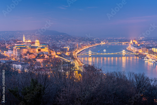 Budapest skyline with Buda castle and Szechenyi Chain Bridge reflect in Danube river during twilight