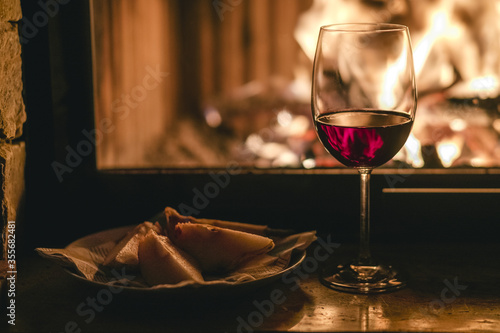
Glass of wine on fireplace background