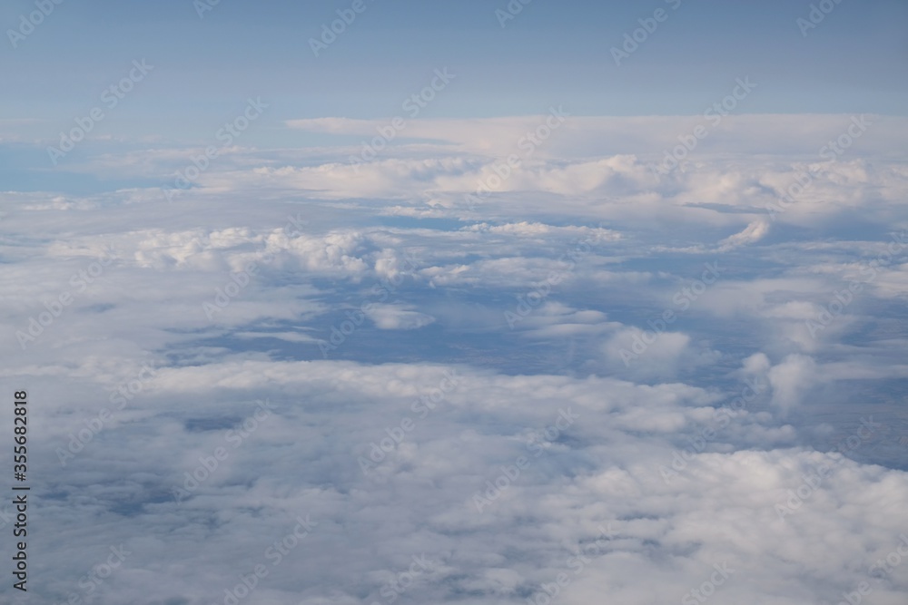 Beautiful white clouds backlit by the sun, view from the airplane window Beautiful white clouds backlit by the sun, view from the airplane window