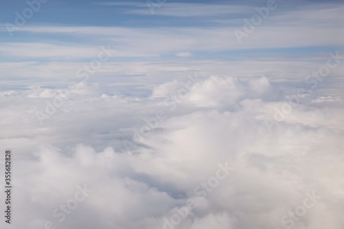 Fototapeta Naklejka Na Ścianę i Meble -  Beautiful white clouds backlit by the sun, view from the airplane window