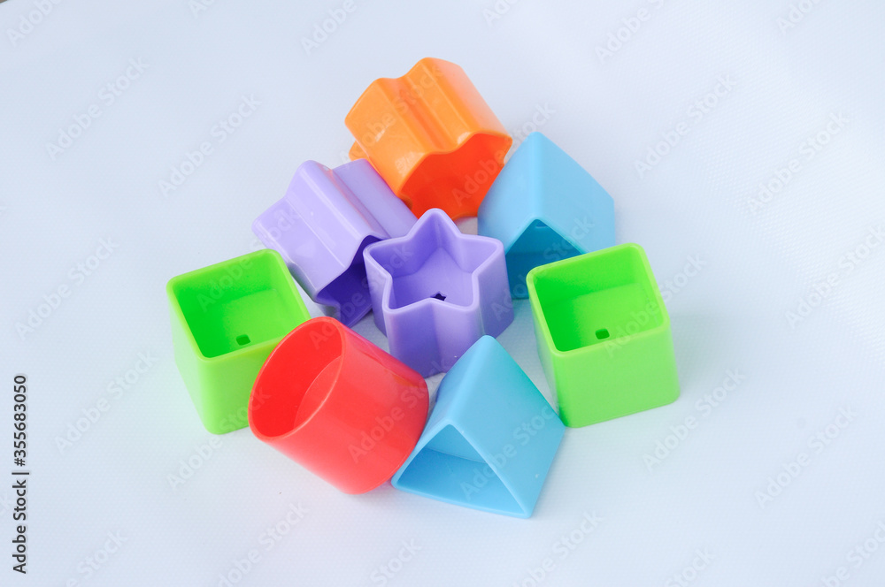 Obraz premium Isolated children's toy blocks in various shapes made of plastic on white background