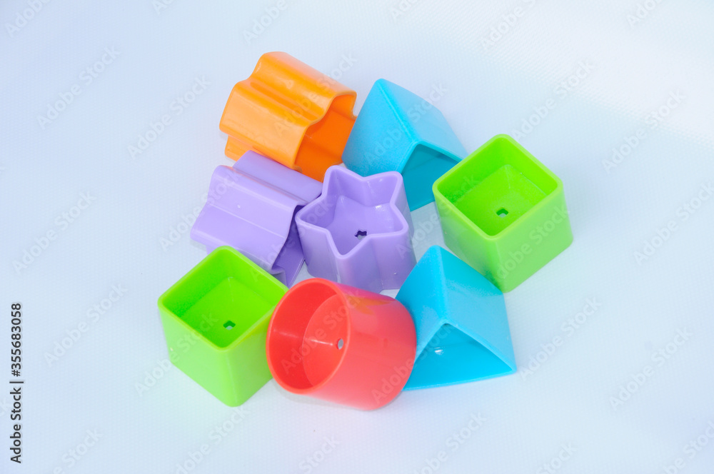Naklejka premium Isolated children's toy blocks in various shapes made of plastic on white background 