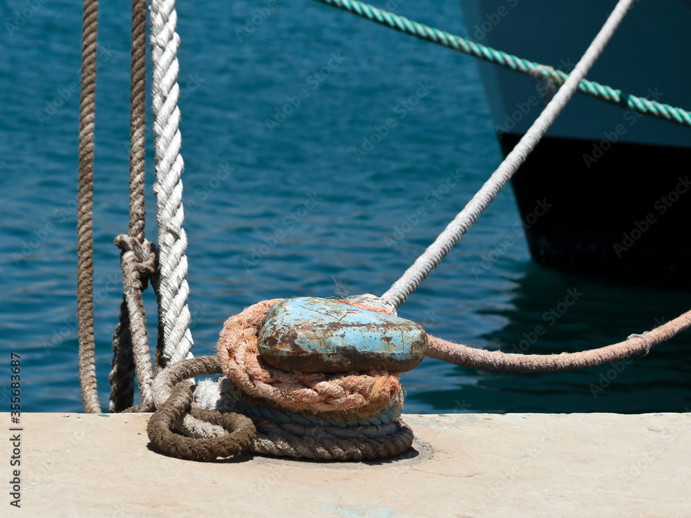 Mooring post with ropes at sea harbor