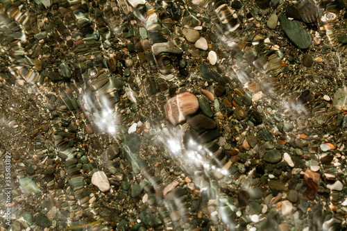 Photography Glowing sea water above beach stones